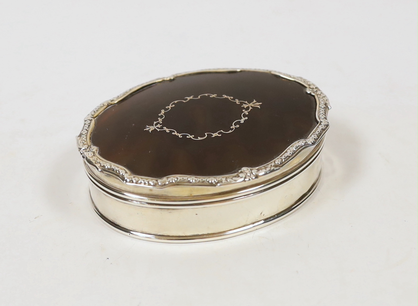 A George V silver and tortoiseshell mounted shaped oval trinket box, by Goldsmiths & Silversmiths Co Ltd, London, 1927, 98mm.